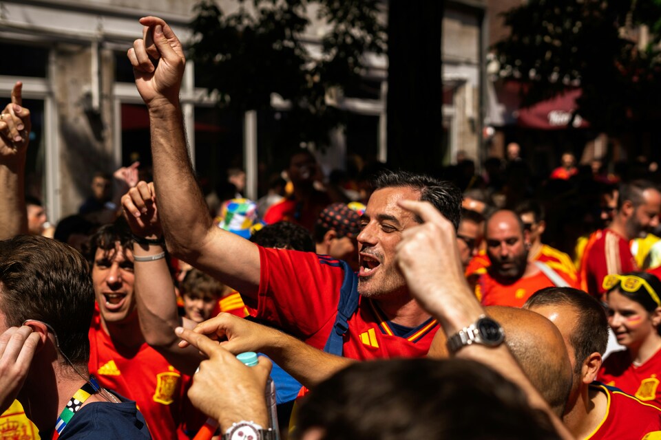 Spain national football team fans waving flags and wearing red in the stadium stands for World Cup 2026.